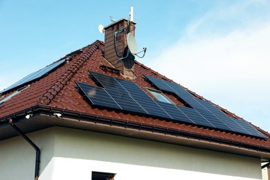 Photo of House with installed solar panels on roof. Alternative energy