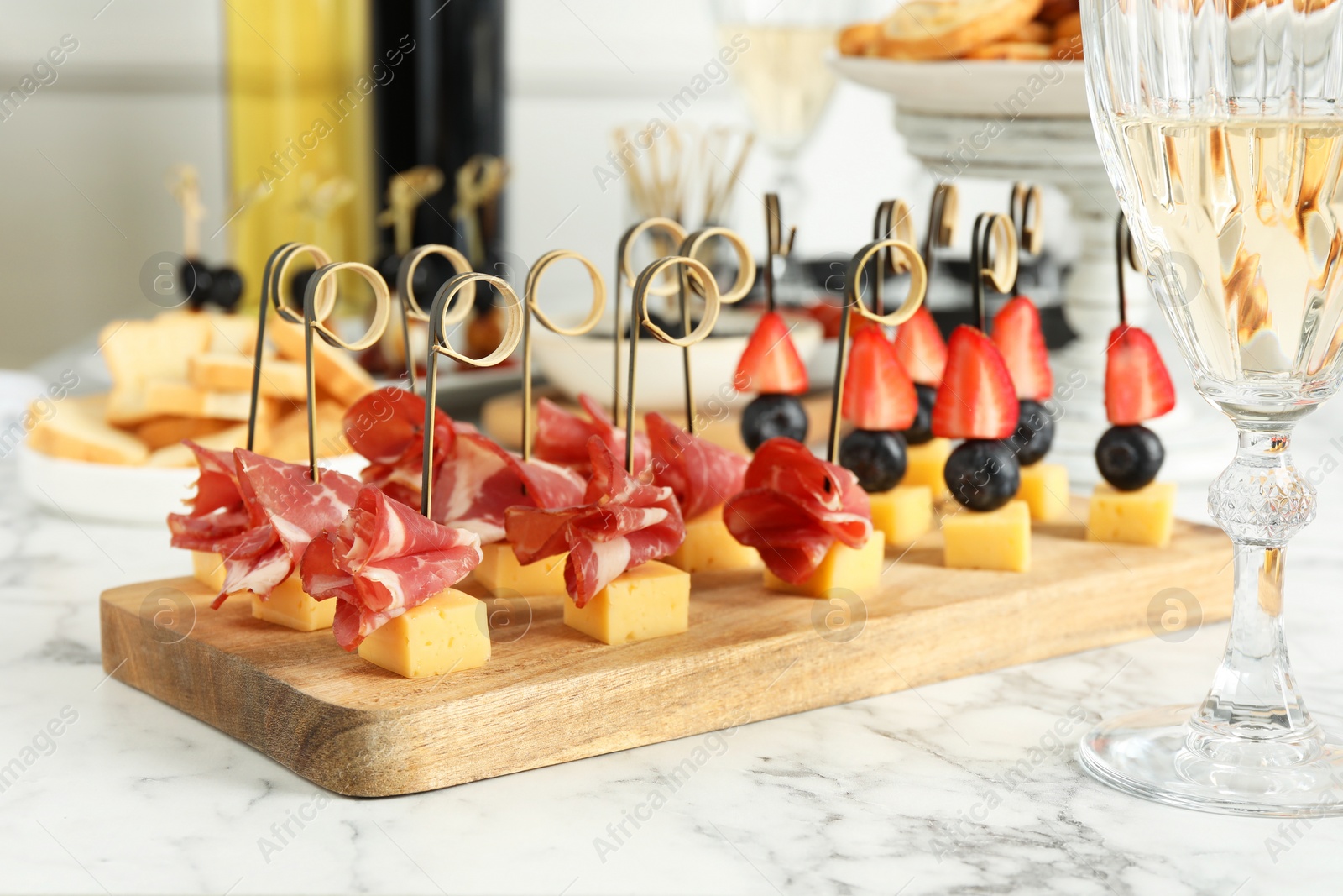 Photo of Different tasty canapes on white marble table, closeup