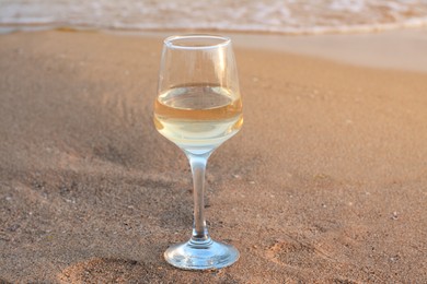 Photo of Glasstasty wine on sand near sea