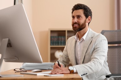 Happy businessman working with documents at wooden table in office