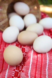 Fresh raw eggs on red fabric, closeup