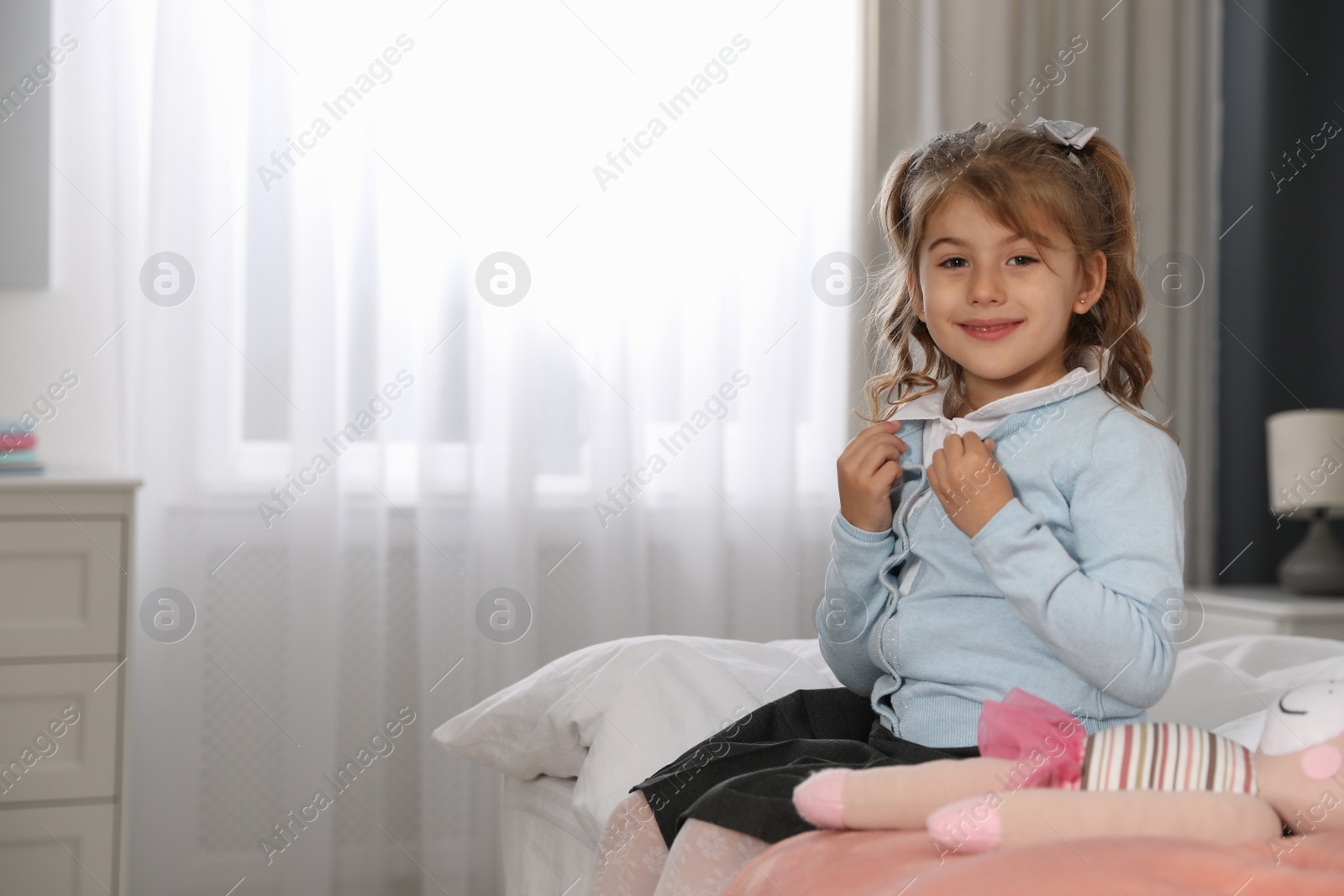 Photo of Little girl getting ready for school in bedroom