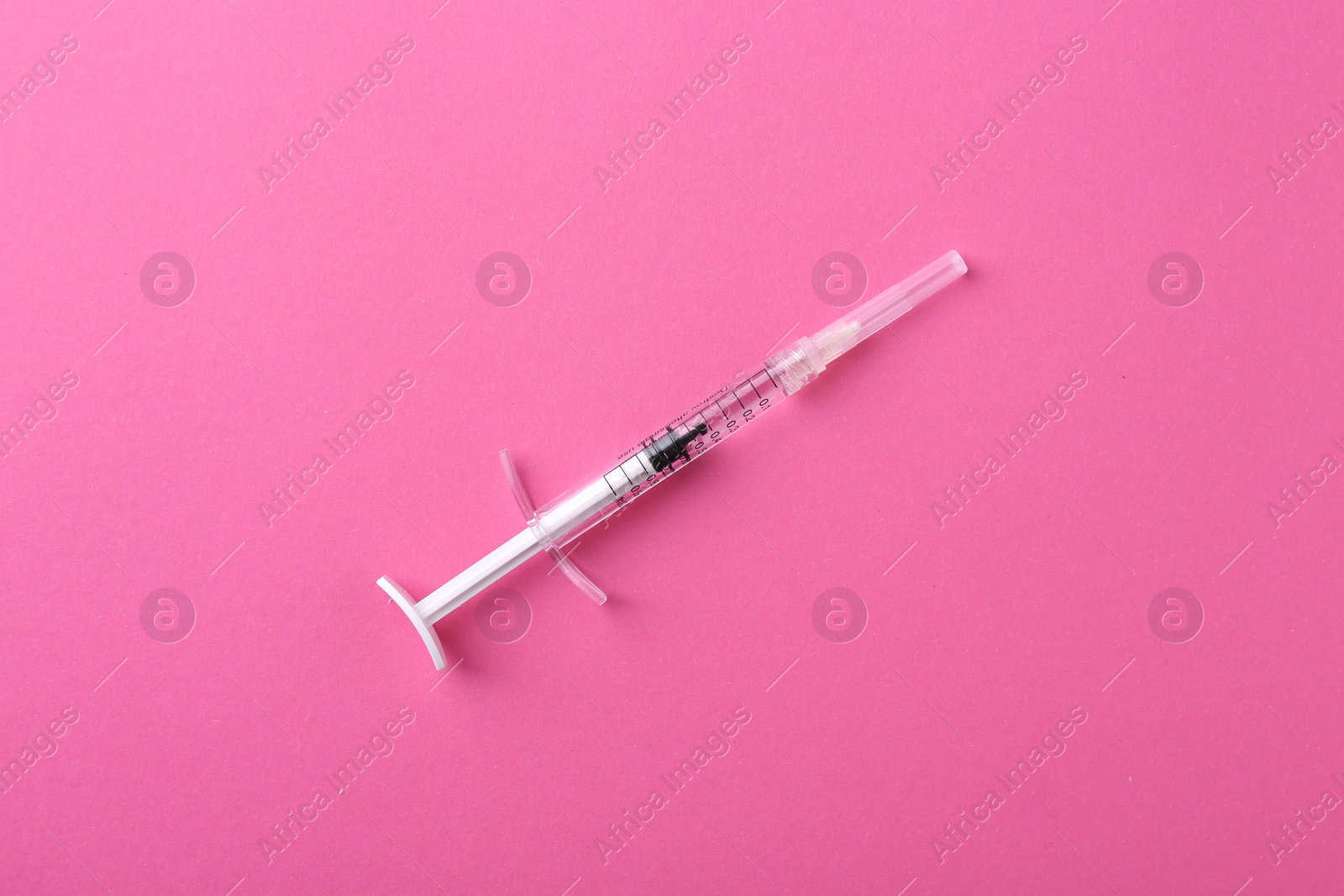 Photo of Injection cosmetology. One medical syringe on pink background, top view