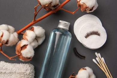 Photo of Flat lay composition with bottle of makeup remover on grey background
