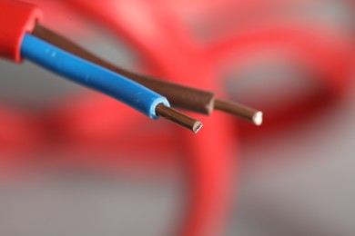 Photo of Colorful electrical wire on blurred background, closeup. Space for text