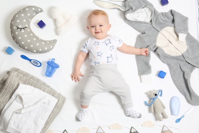 Photo of Cute little baby with clothing and accessories on white background, top view