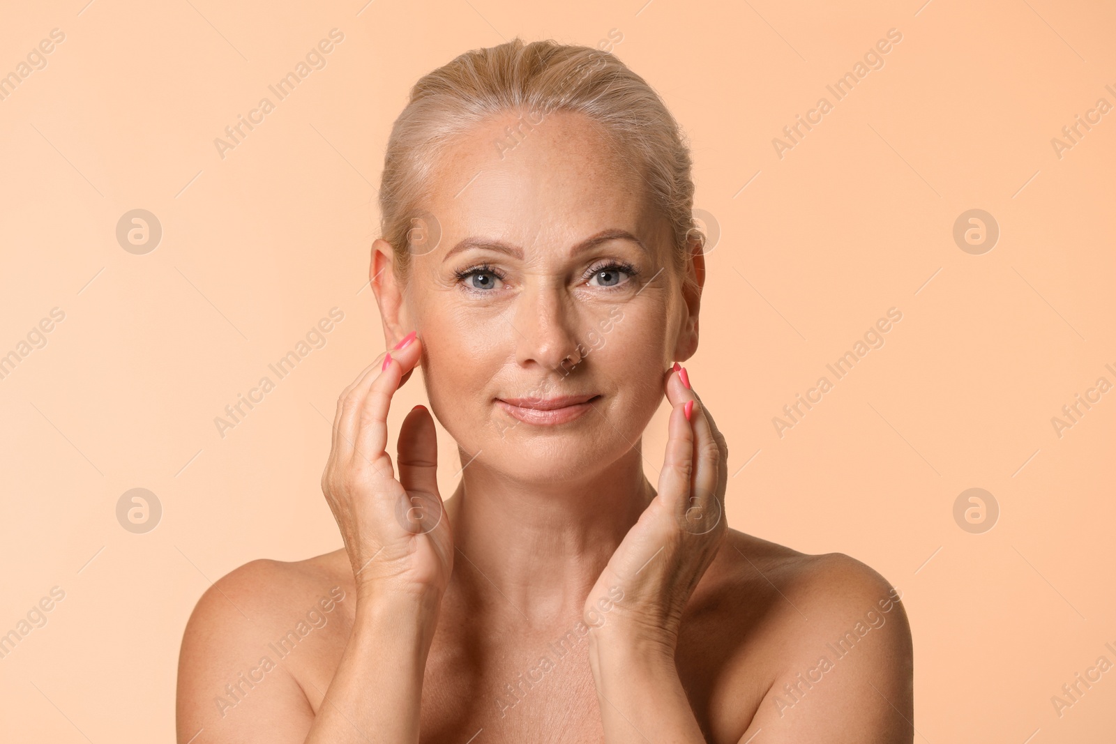 Photo of Portrait of beautiful mature woman with perfect skin on beige background