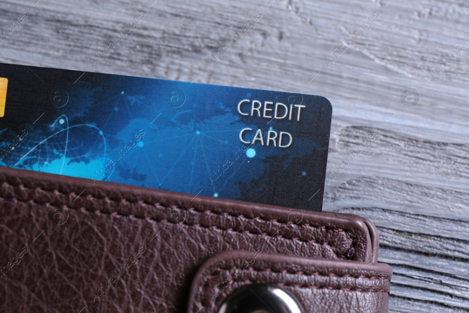 Photo of Credit card in leather wallet on grey wooden table, top view