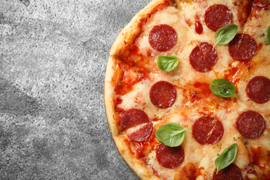 Hot delicious pepperoni pizza on grey table, top view. Space for text