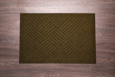 Photo of Stylish door mat on wooden floor, top view