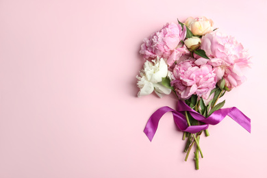 Photo of Bouquet of beautiful peonies with ribbon on pink background, flat lay. Space for text