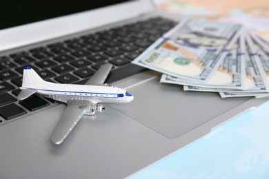 Photo of Composition with laptop, toy plane and money on color background. Travel agency