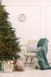 Photo of Many different gift boxes and firewood under Christmas tree indoors