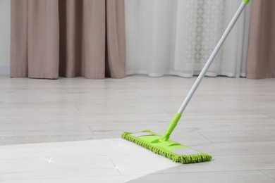 Image of Washing floor with mop in room, space for text. Clean trace on dirty surface