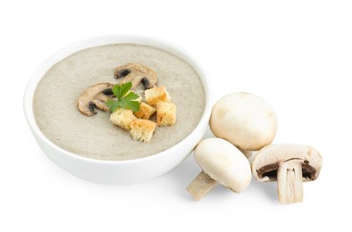 Delicious mushroom cream soup with croutons in bowl and mushrooms isolated on white