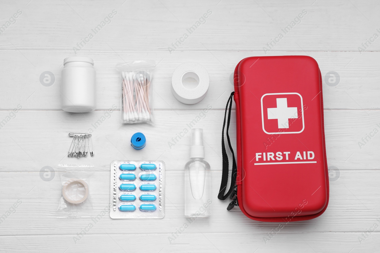 Photo of Flat lay composition with first aid kit on white wooden table