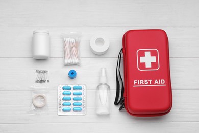 Photo of Flat lay composition with first aid kit on white wooden table