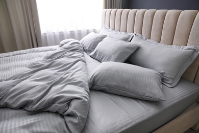 Photo of Comfortable bed with soft blanket and pillows indoors