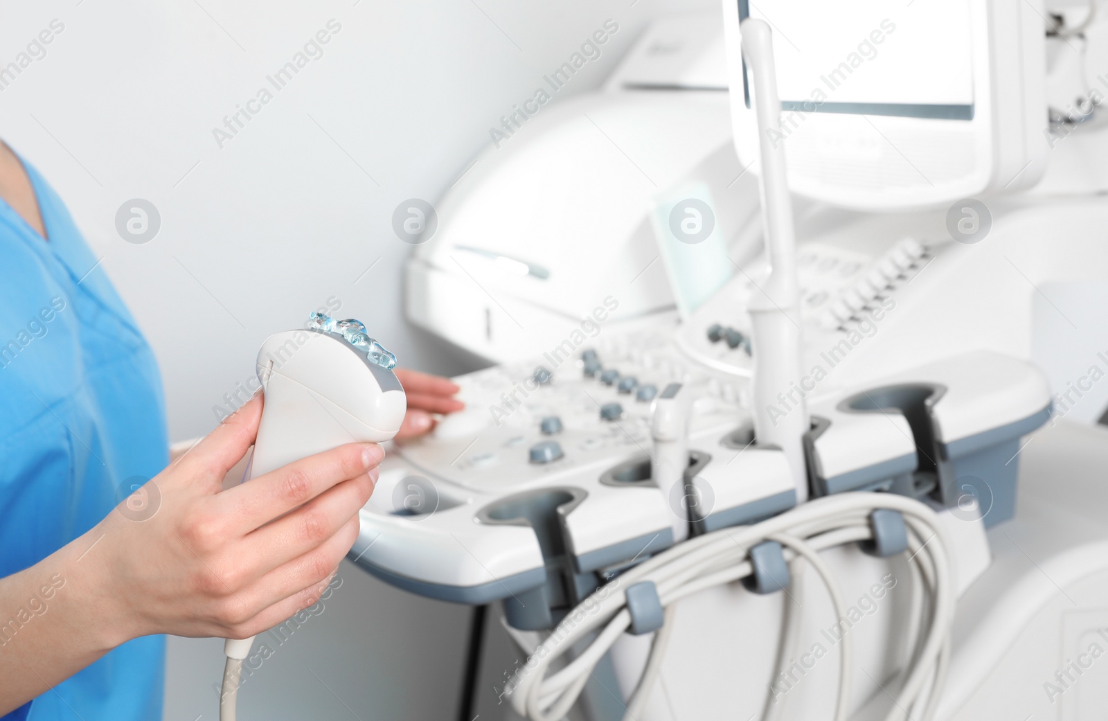 Photo of Professional sonographer using modern ultrasound machine in clinic, closeup