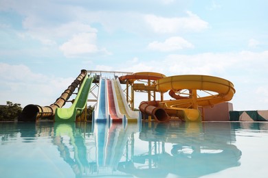 Photo of Beautiful view of water park with colorful slides and swimming pool on sunny day
