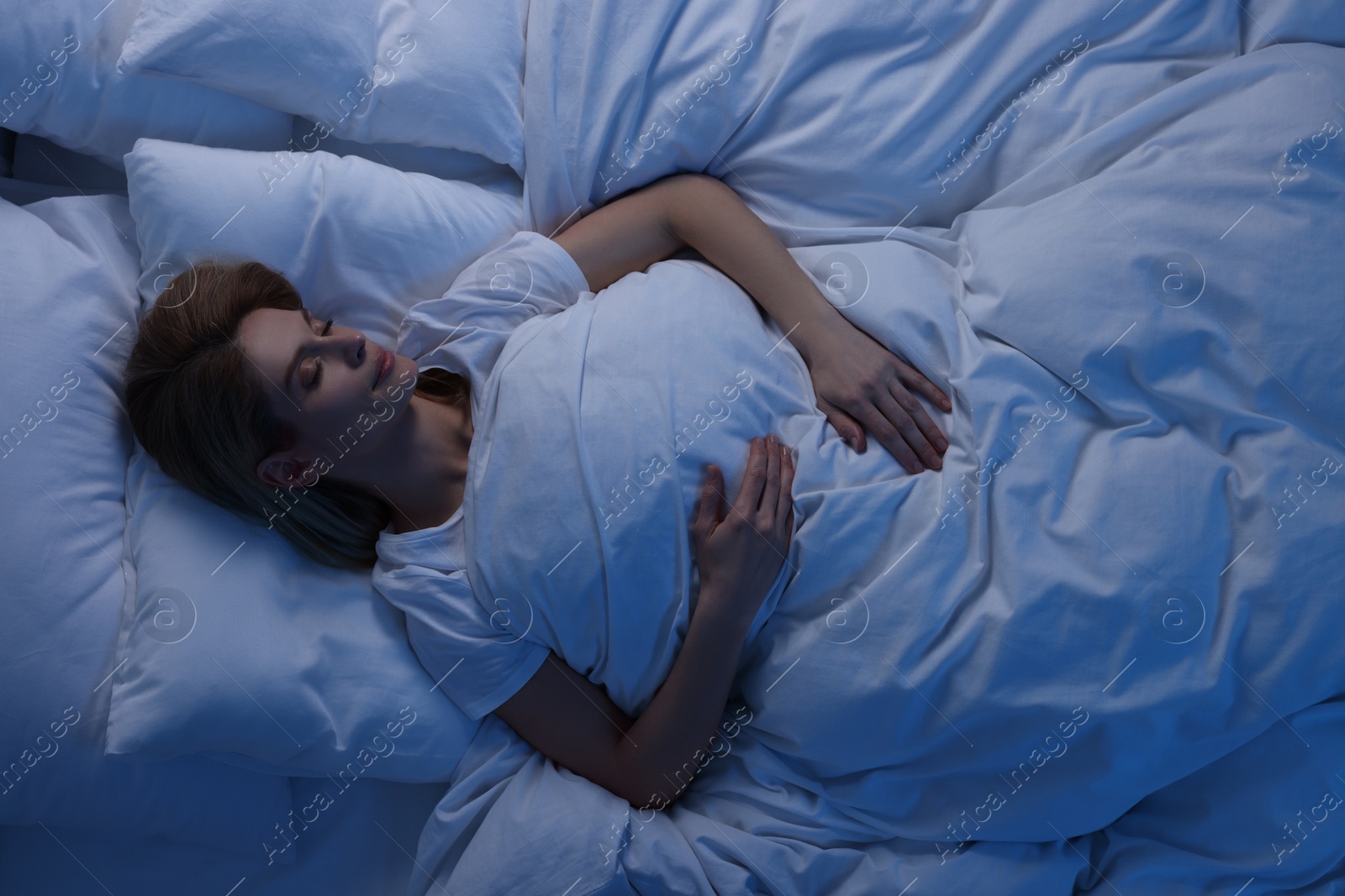 Photo of Woman sleeping in bed at night, above view