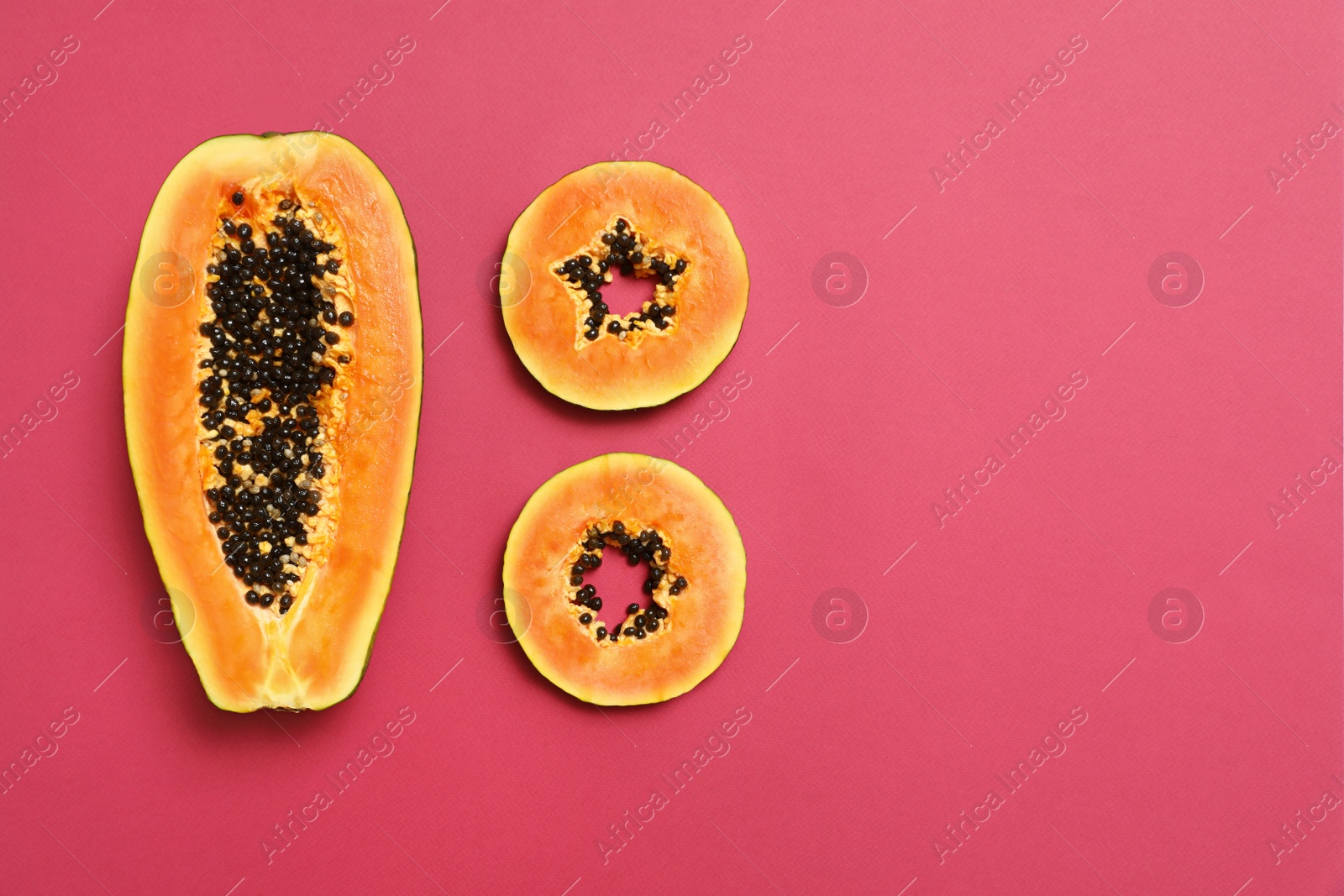 Photo of Flat lay composition with cut papaya on pink background, space for text