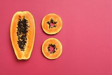 Photo of Flat lay composition with cut papaya on pink background, space for text