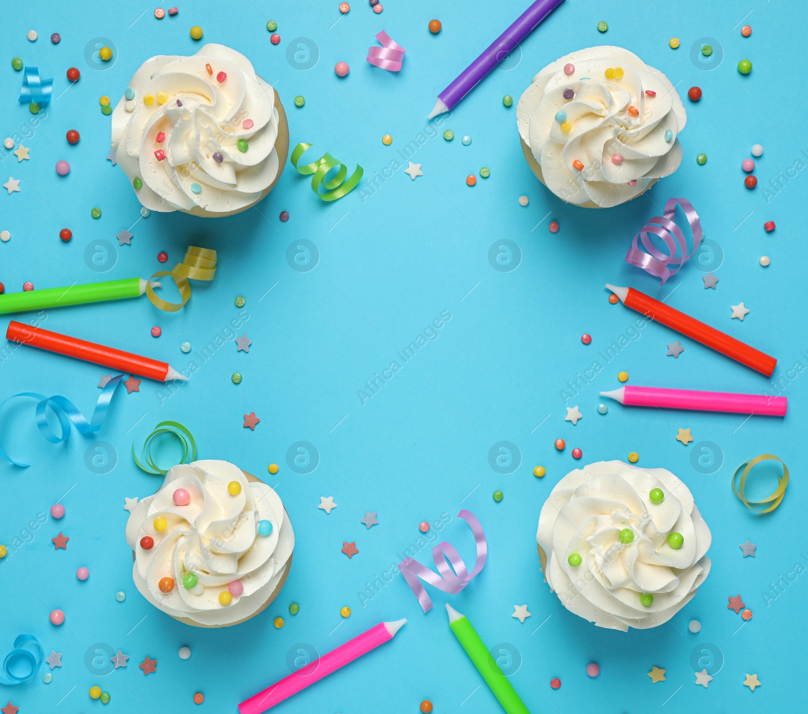 Photo of Flat lay composition with cupcakes on light blue background, space for text. Birthday party