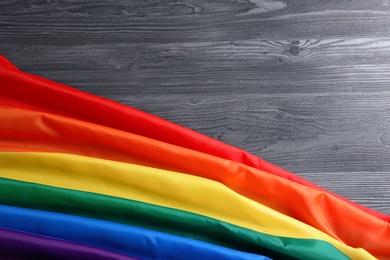 Photo of Bright rainbow gay flag on wooden background, top view with space for text. LGBT community