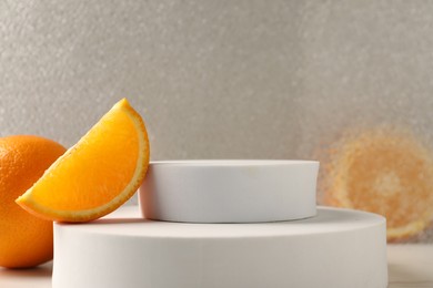 Photo of Presentation for product. Podium and tasty fresh oranges on table, closeup. Space for text