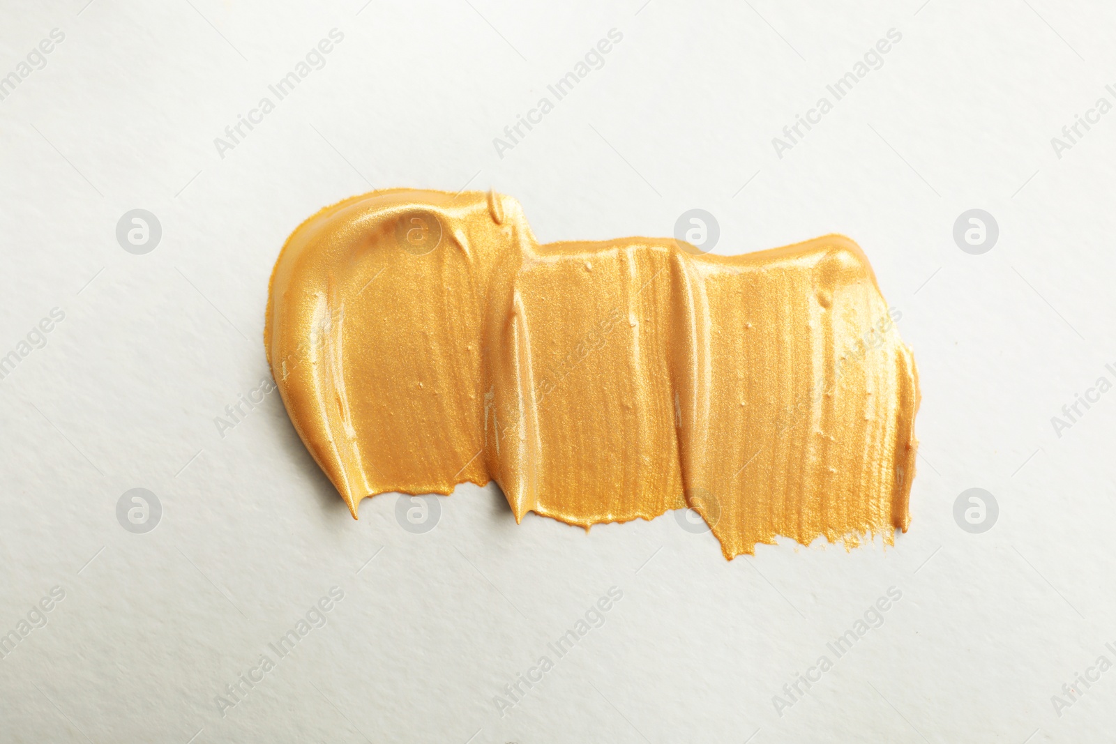 Photo of Golden paint brush strokes on white background