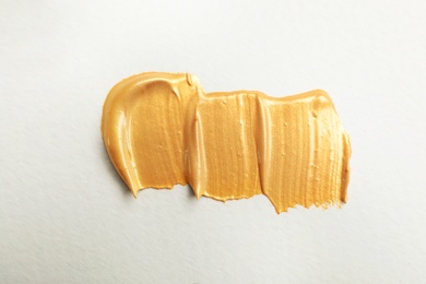 Photo of Golden paint brush strokes on white background