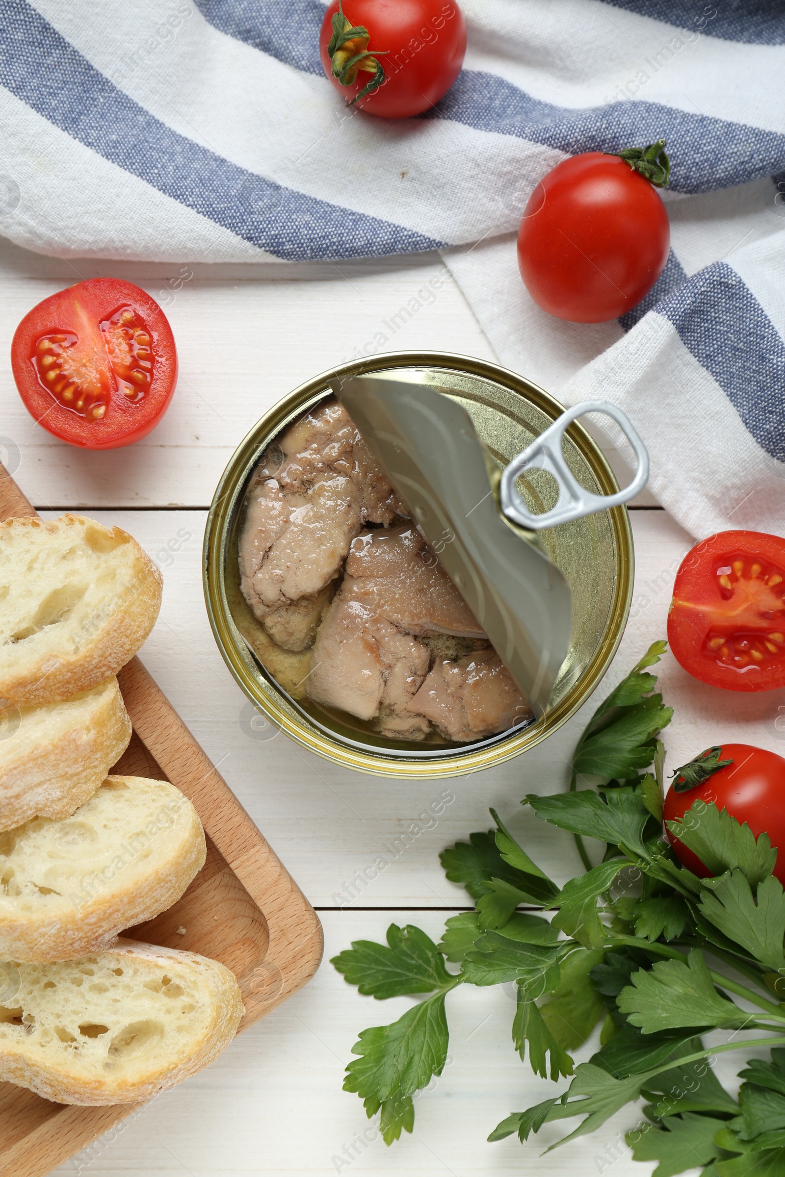 Photo of Flat lay composition with tin can of tasty cod liver and different products on white wooden table