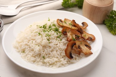 Photo of Delicious rice with parsley and mushrooms on white table