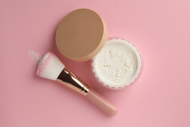 Photo of Rice loose face powder and makeup brush on pink background, flat lay