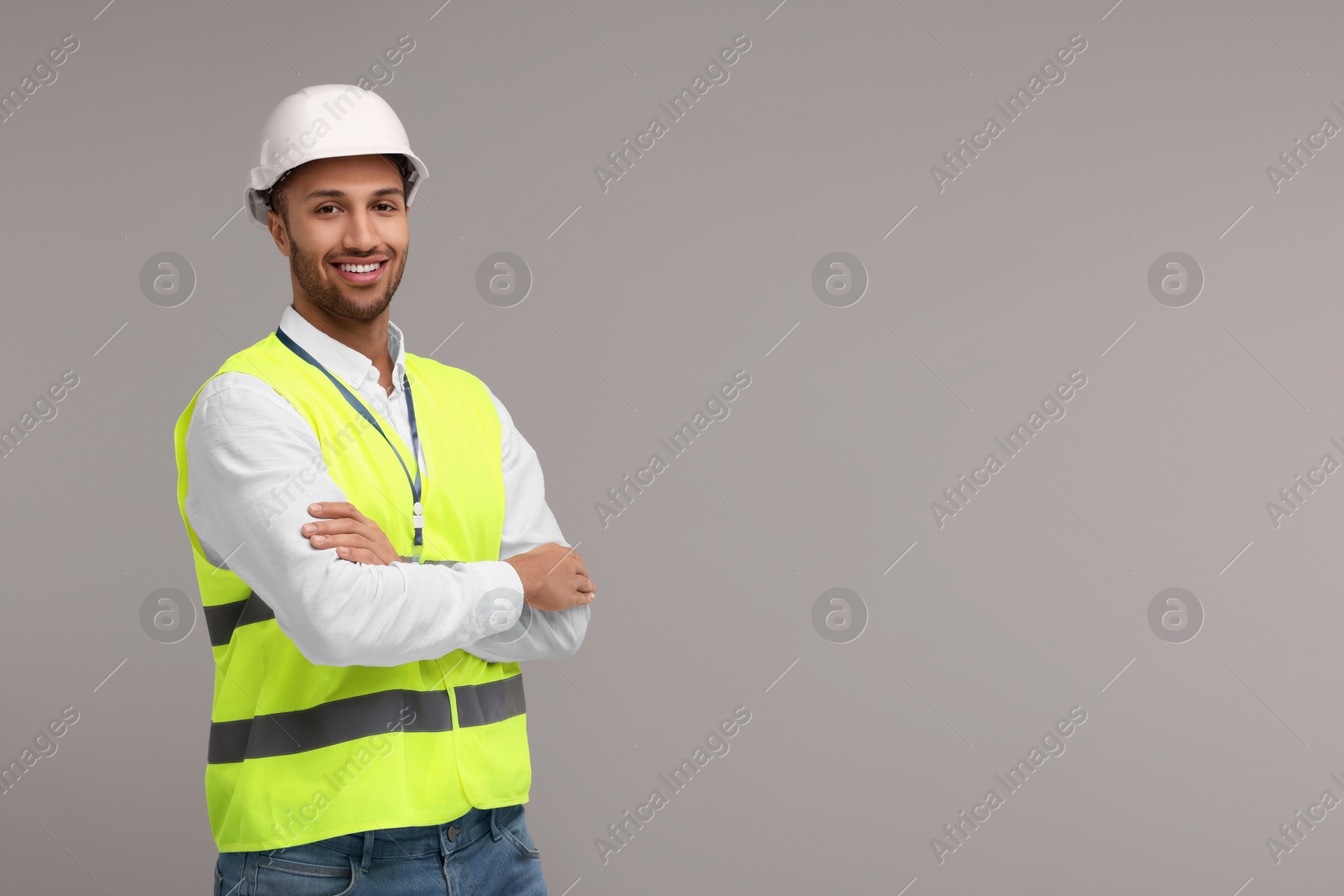 Photo of Engineer in hard hat on grey background, space for text