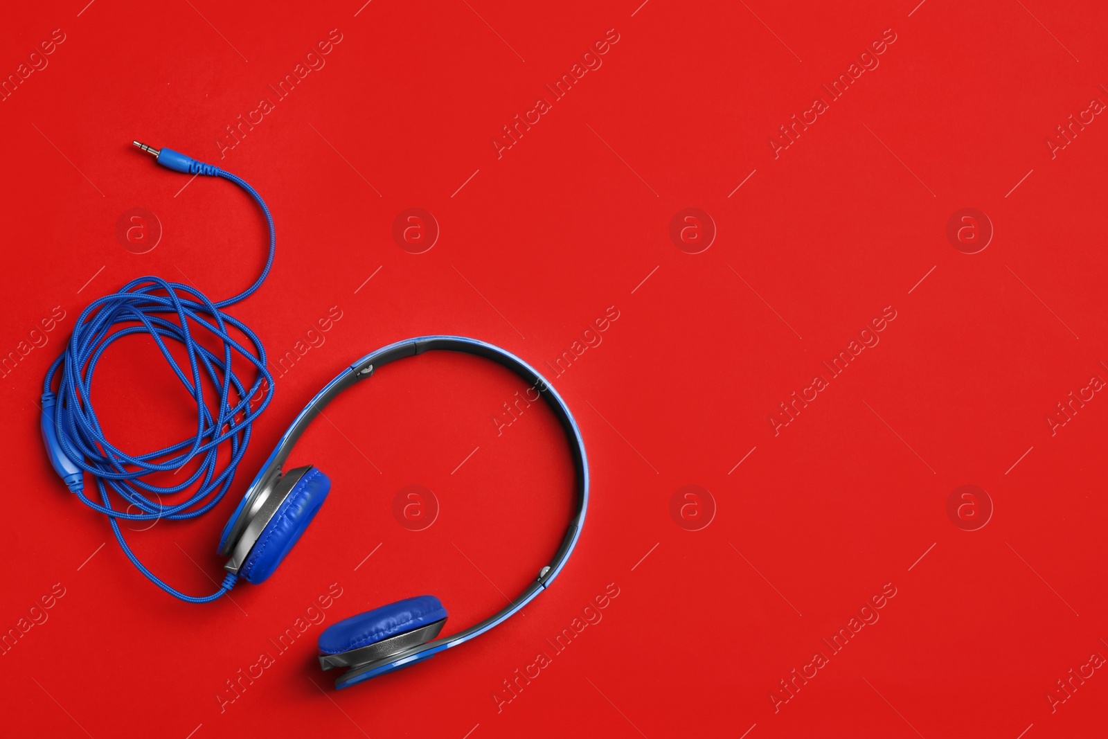 Photo of Stylish headphones on color background, top view. Space for text