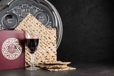 Photo of Symbolic Pesach (Passover Seder) items on black table, space for text