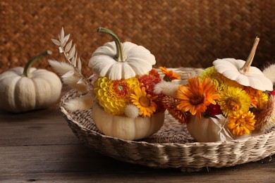 Composition with small pumpkins, beautiful flowers and spikelets on wooden table, closeup