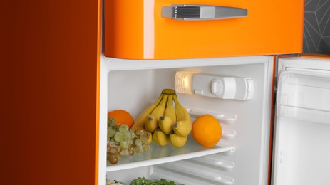 Photo of Modern open refrigerator with many different fresh fruits