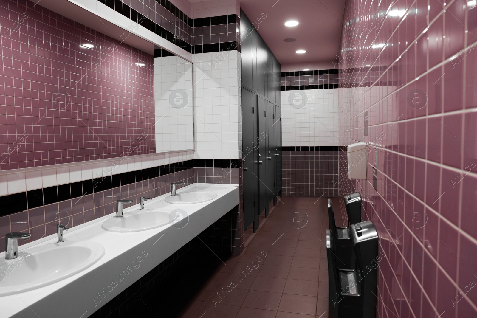 Photo of Public toilet interior with sinks and mirror