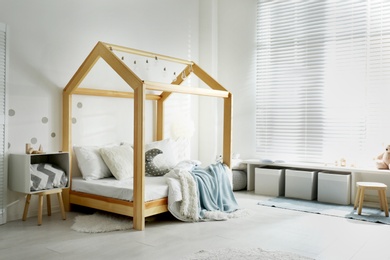 Photo of Cozy child room interior with comfortable bed