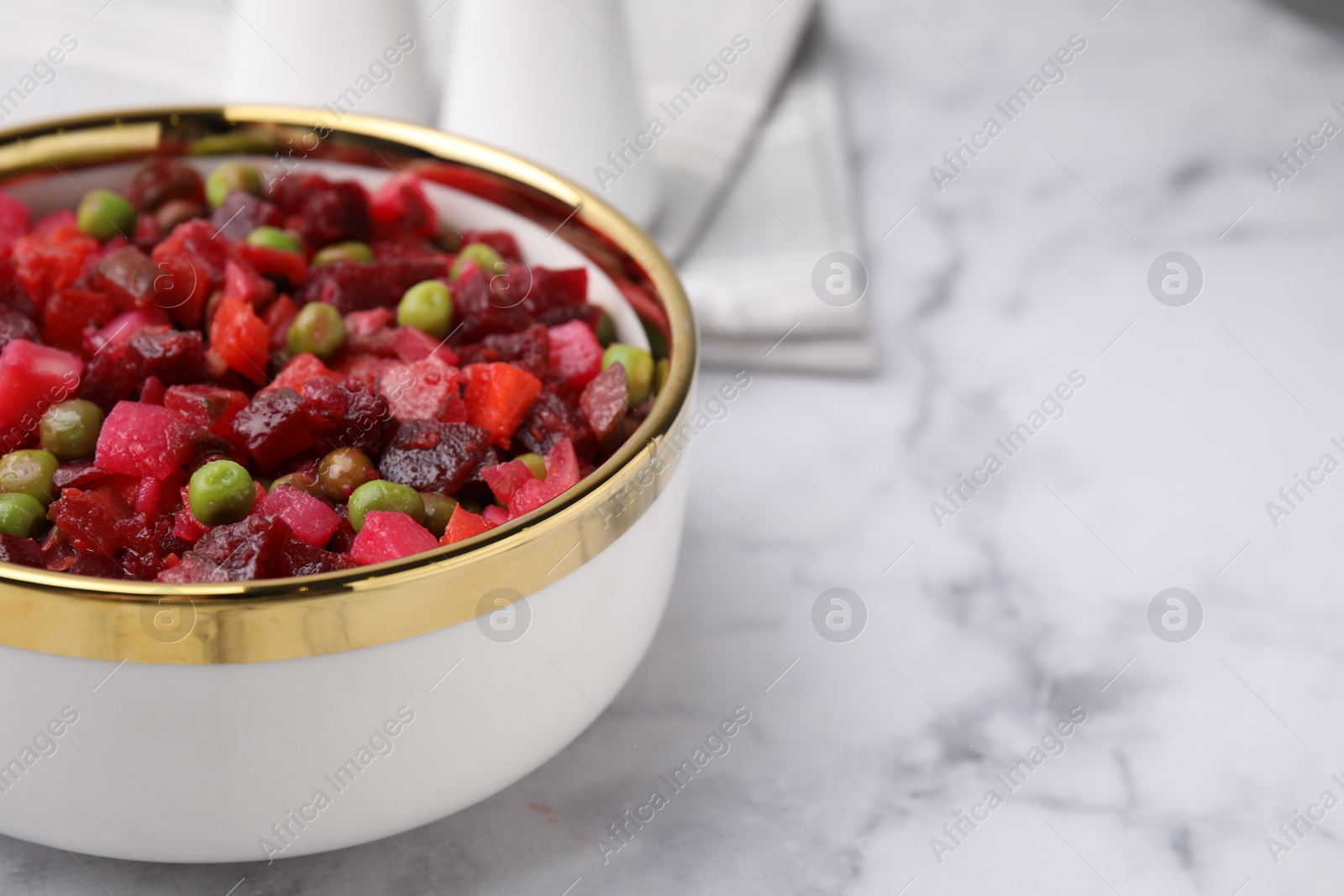 Photo of Delicious vinaigrette salad on white marble table, closeup. Space for text