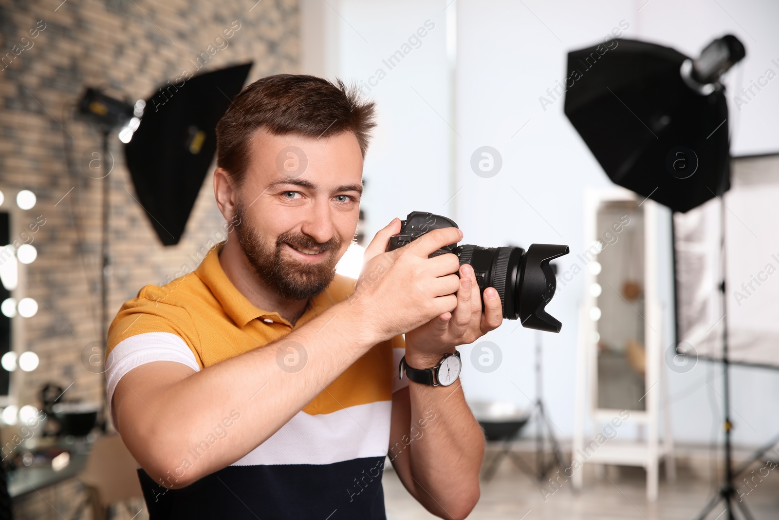 Photo of Professional photographer with camera in photo studio