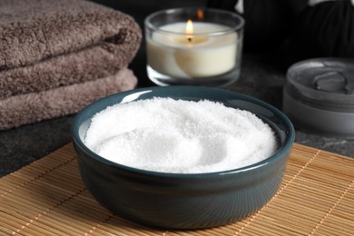 Photo of Beautiful composition with sea salt, burning candle and different spa products on grey table, closeup