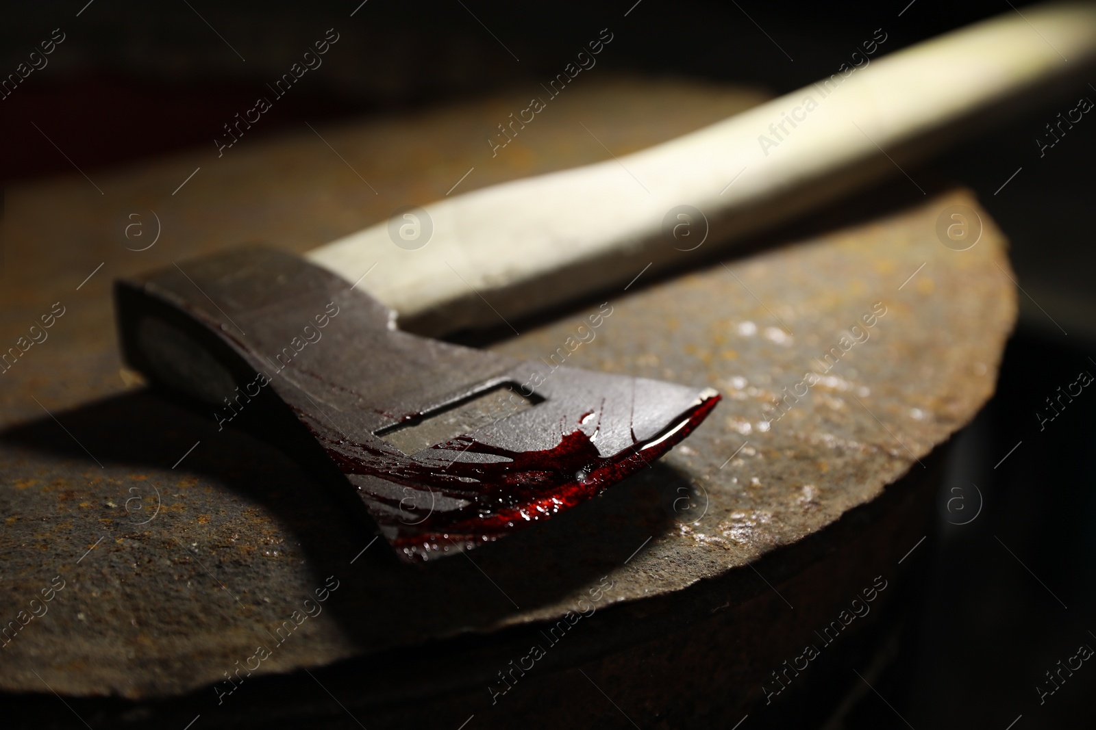 Photo of Axe with blood on rusty metal surface, closeup