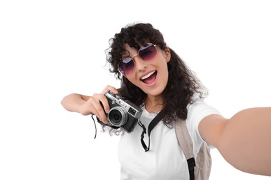 Photo of Beautiful woman in sunglasses with camera taking selfie on white background