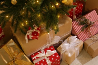 Photo of Gift boxes under Christmas tree with fairy lights