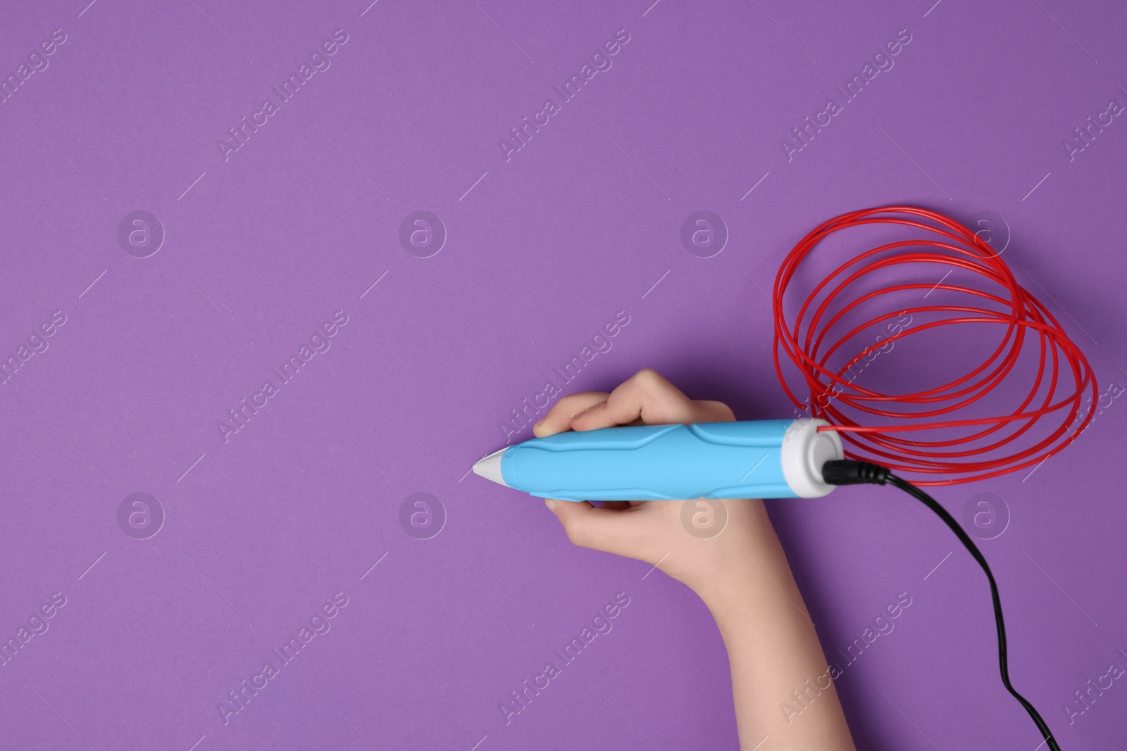 Photo of Boy drawing with stylish 3D pen on purple background, top view. Space for text