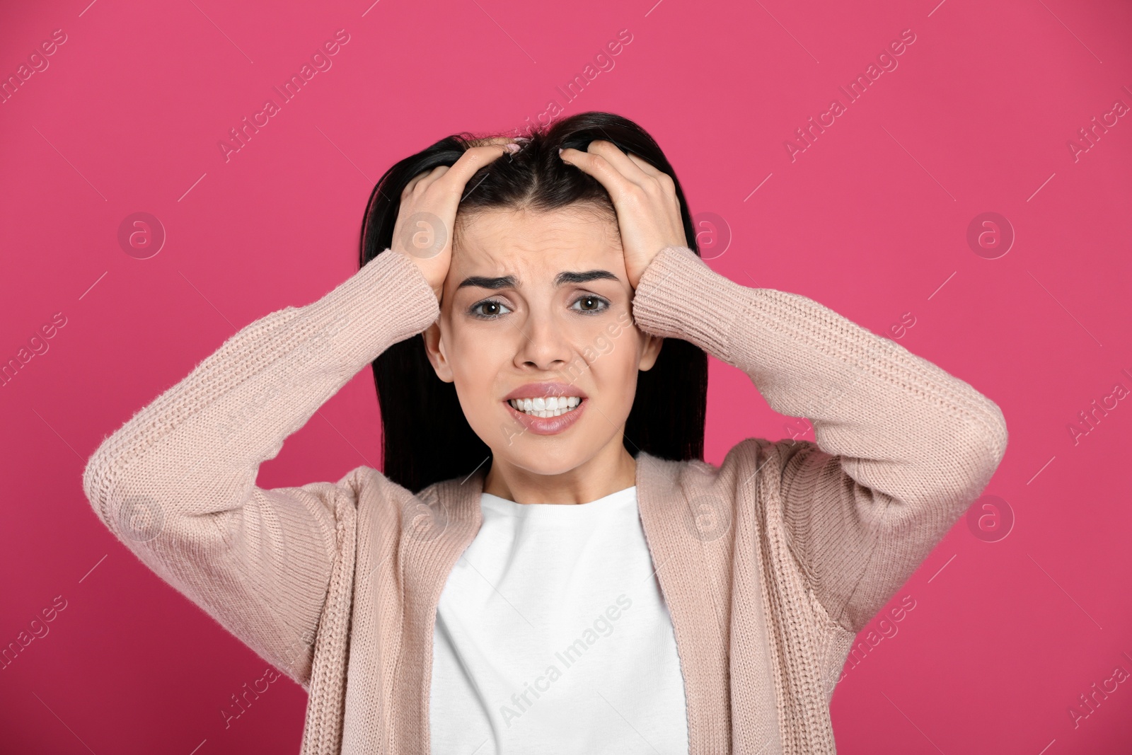 Photo of Woman suffering from migraine on pink background